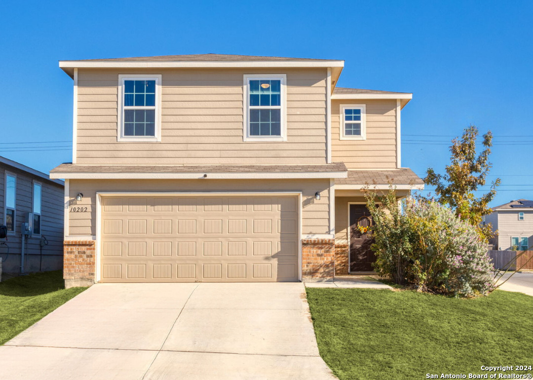 a front view of a house with a yard and garage