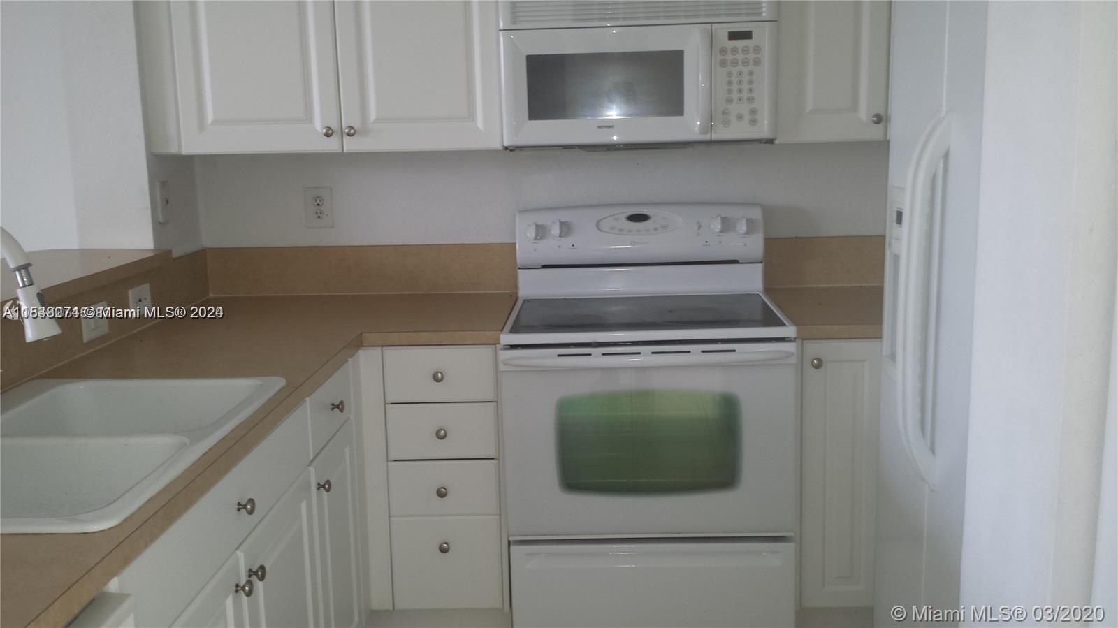 a kitchen with white cabinets and black appliances