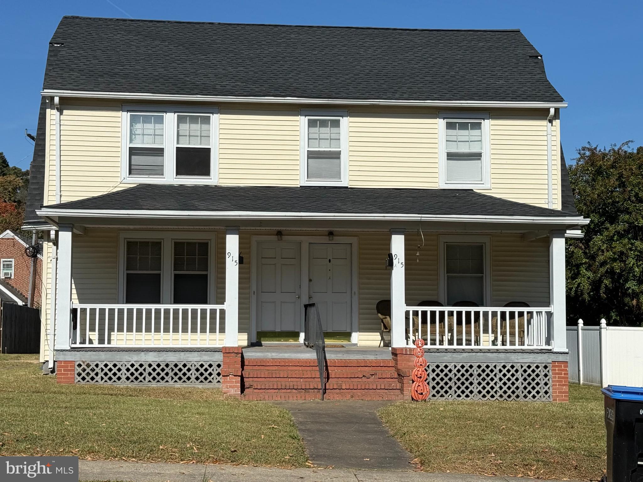 a view of a house with a small yard and wooden fence