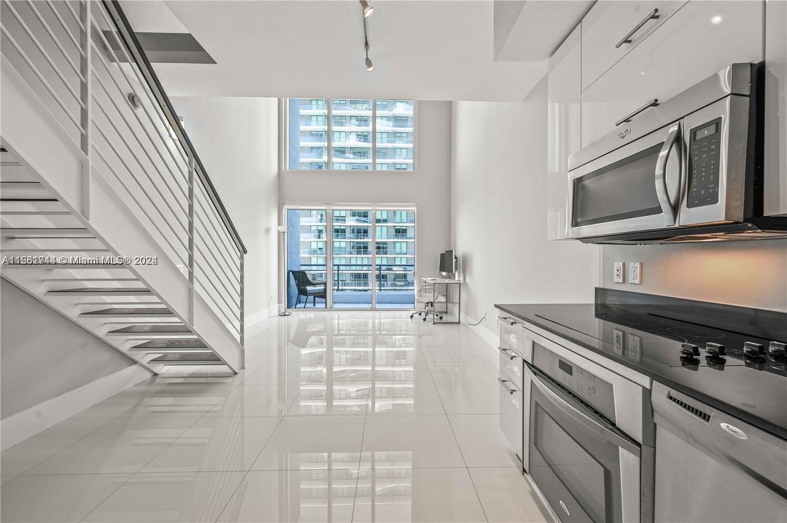 a kitchen with granite countertop a stove a sink and a microwave