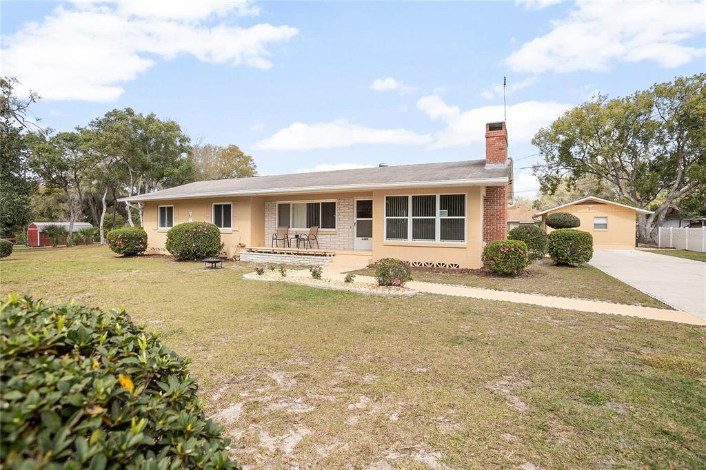 a house view with swimming pool and porch