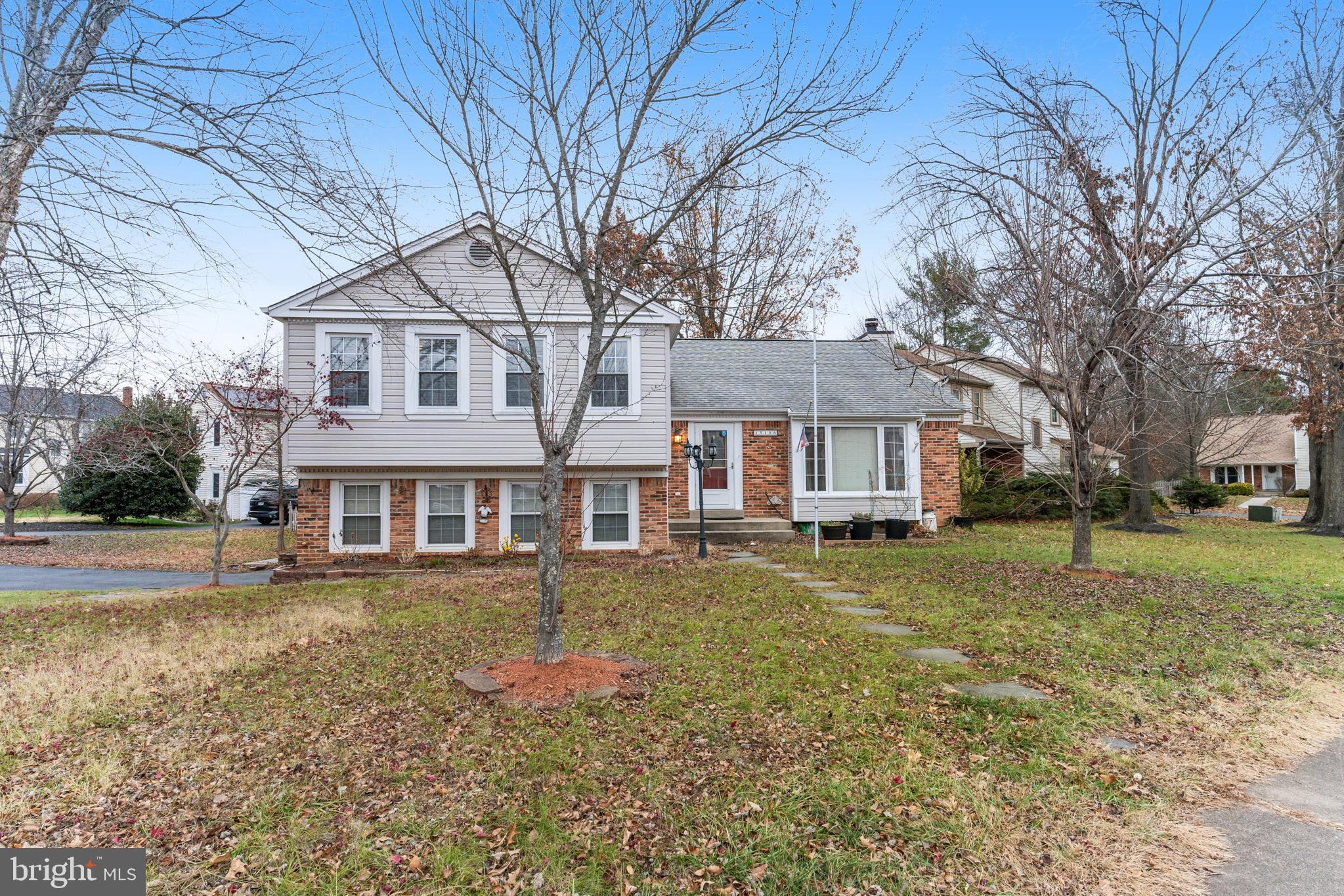 a front view of a house with a yard covered with trees