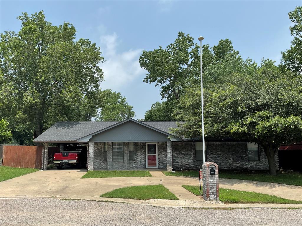 a front view of a house with a yard and trees