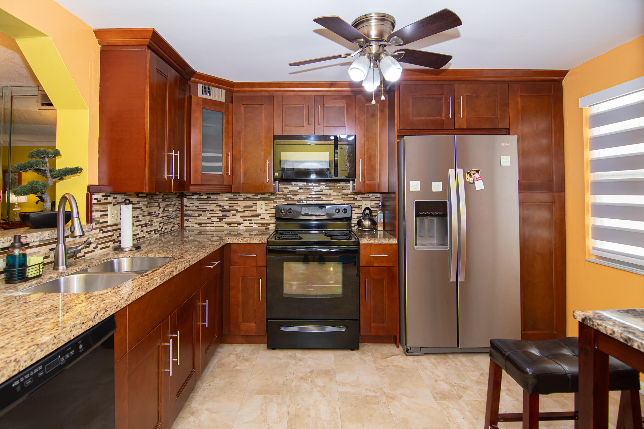 a kitchen with stainless steel appliances granite countertop a refrigerator a stove and a sink