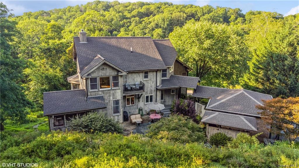 an aerial view of a house with table and chairs and wooden fence