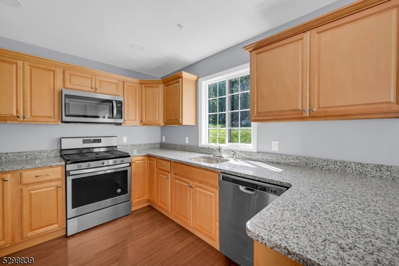 a kitchen with stainless steel appliances granite countertop a sink stove and microwave