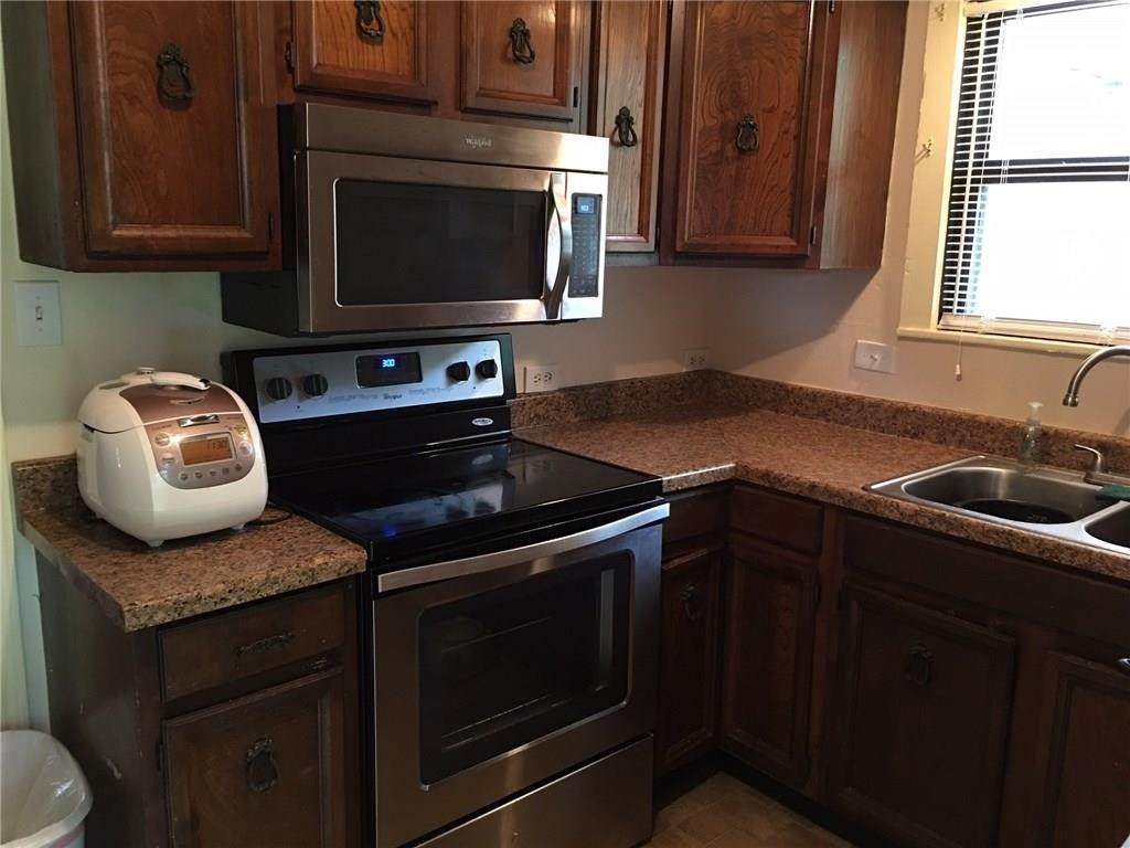 Kitchen with dark brown cabinets, stainless steel appliances, and sink