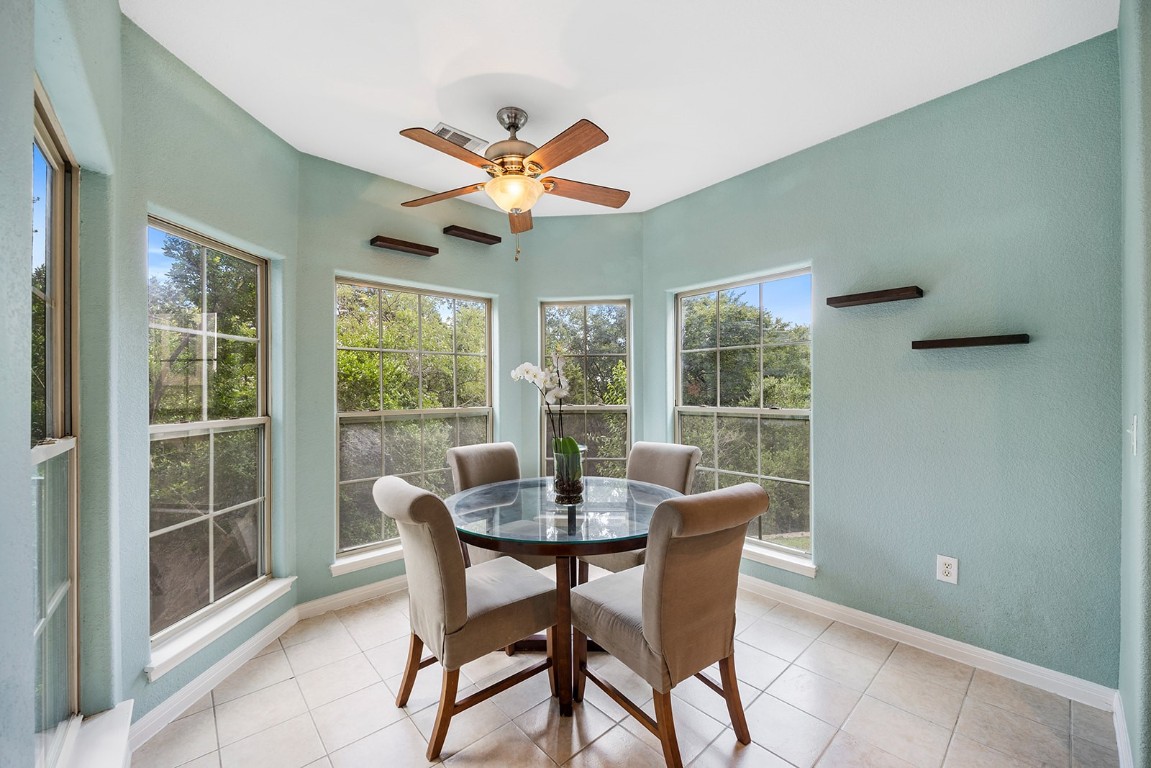 a dining room with furniture a chandelier and a large window