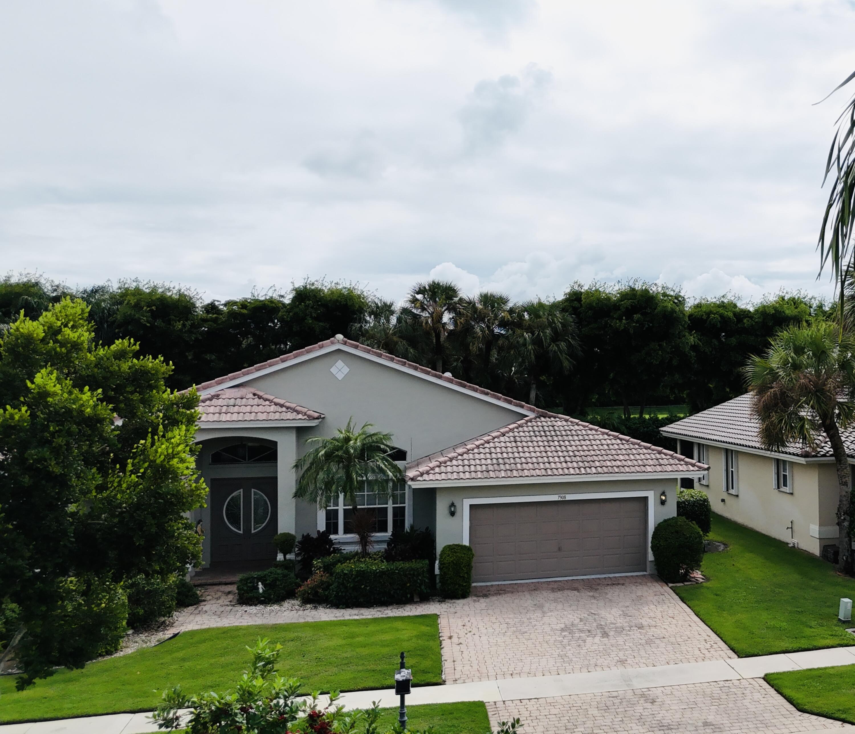 a view of house with garden and tall tress