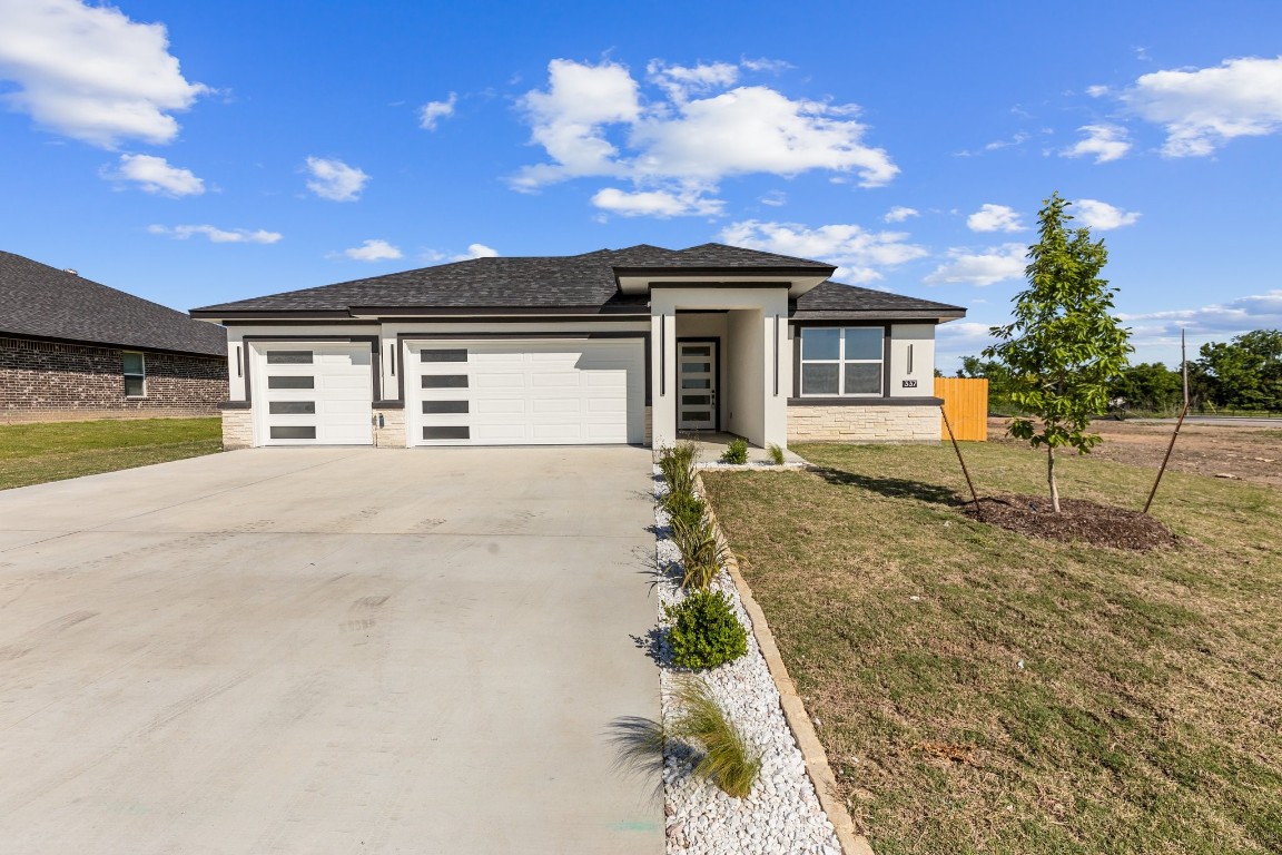 a front view of a house with a yard and garage