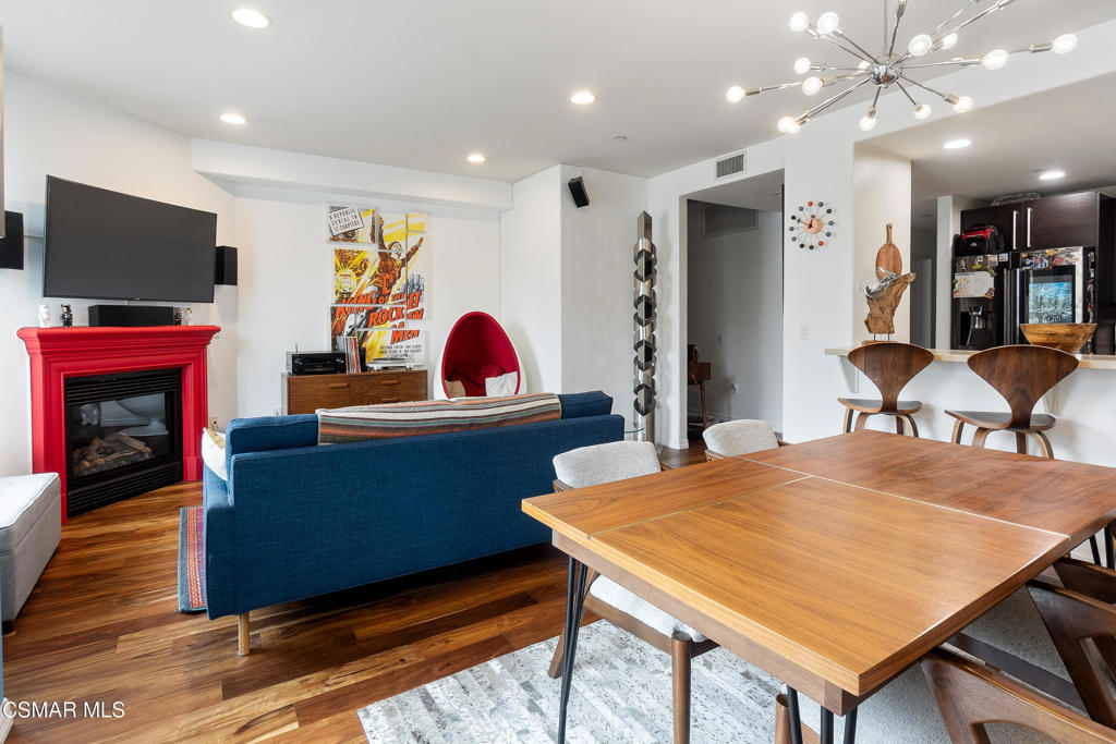 a living room with furniture a flat screen tv and kitchen view