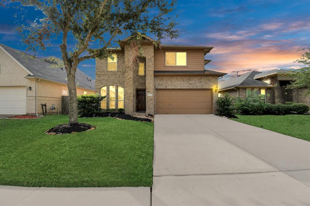 a front view of a house with a yard and garage