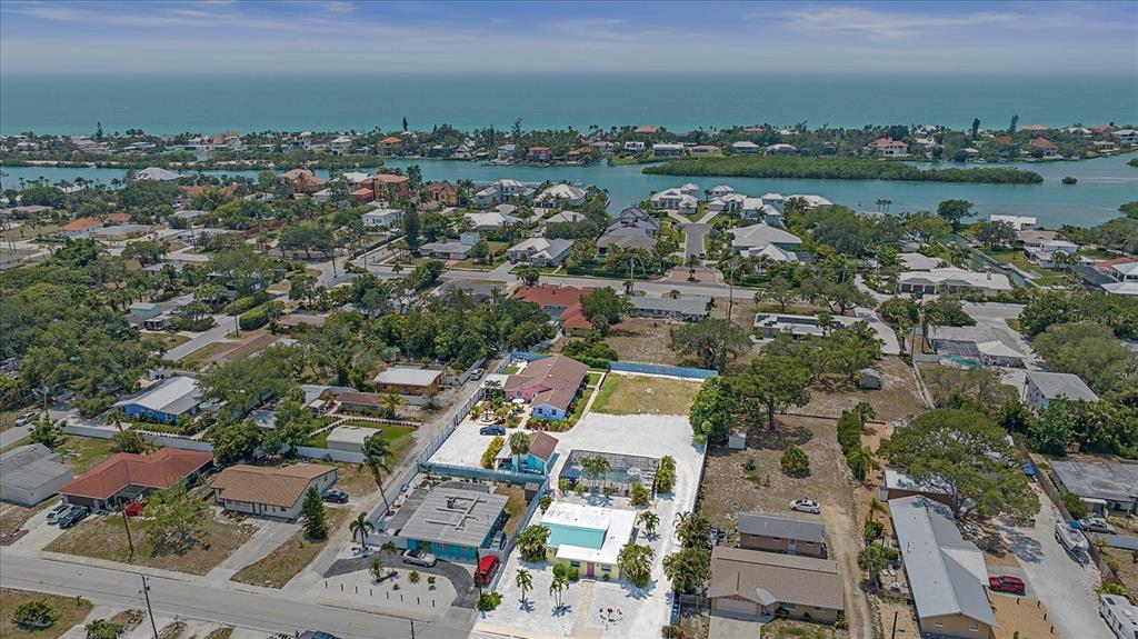 an aerial view of a city with lots of residential buildings ocean and mountain view in back