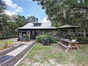 a view of house with a yard and furniture