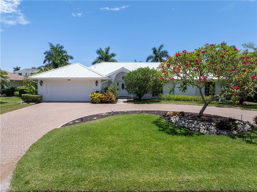 a white house with a yard and a garden