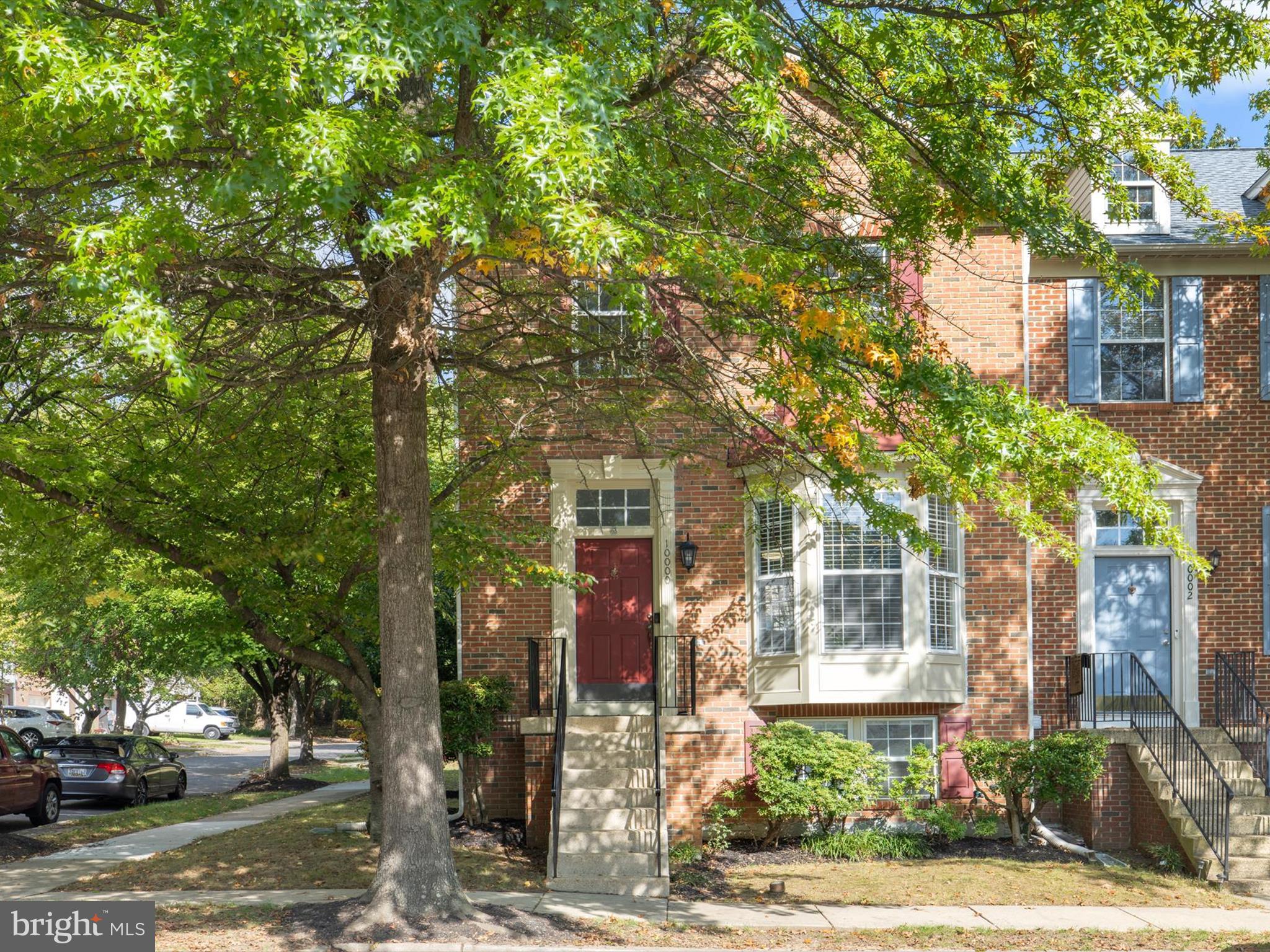 a front view of a house with a tree