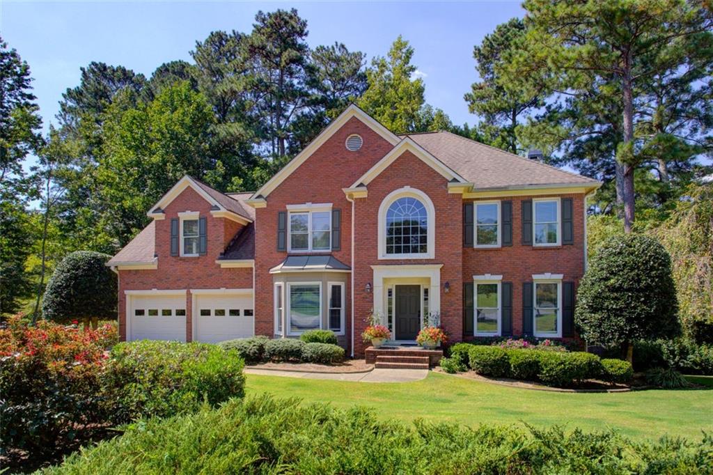 a front view of a house with yard and green space