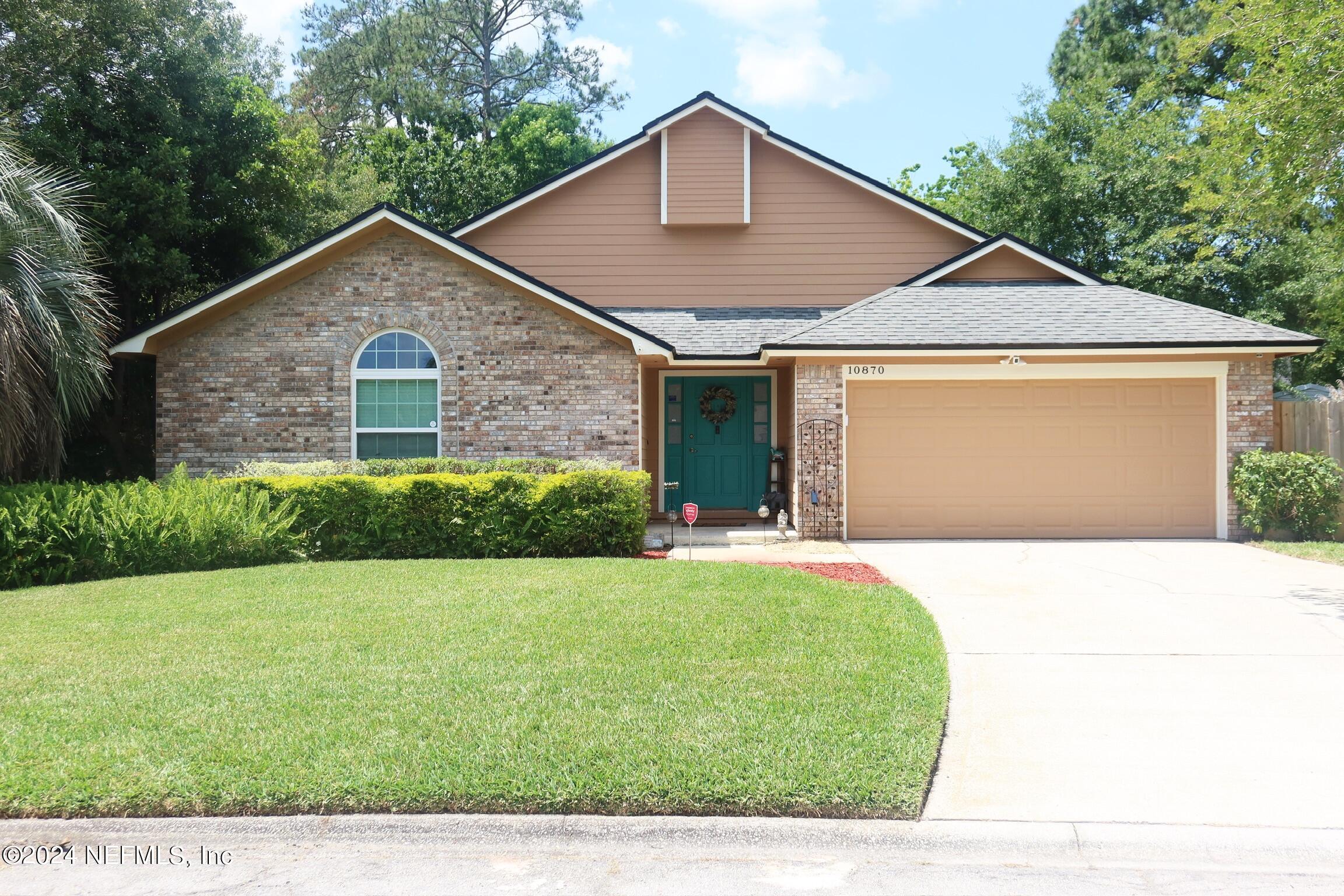 a front view of house with yard and garage