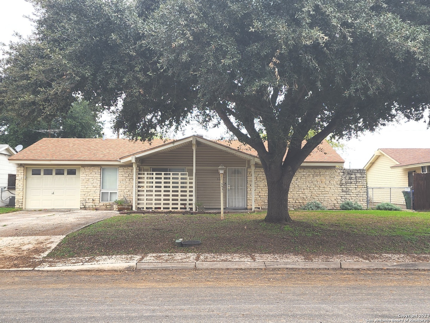 a front view of a house with a garden and trees