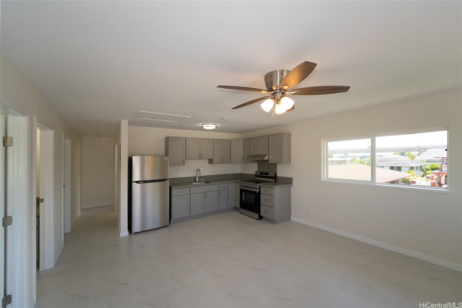 a view of a kitchen with a sink and a ceiling fan