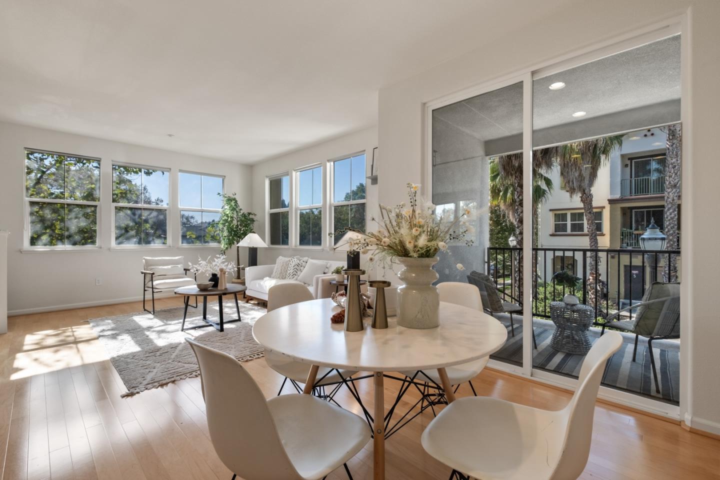 a dining room with furniture a floor to ceiling window and wooden floor