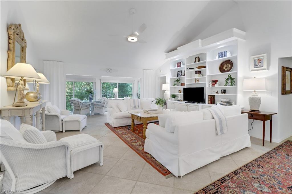 a living room with furniture a fireplace and a large window