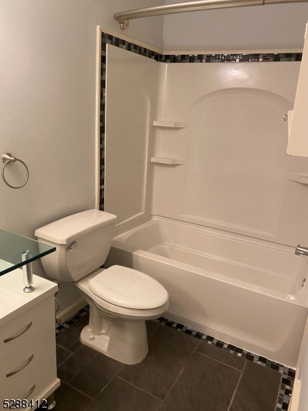 a white toilet sitting next to a bath tub and shower