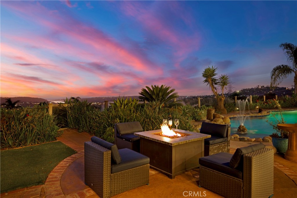 a view of a patio with couches table and chairs with potted plants and mountain view