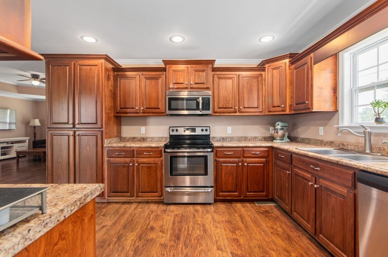 a kitchen with stainless steel appliances granite countertop a stove a sink dishwasher and a refrigerator