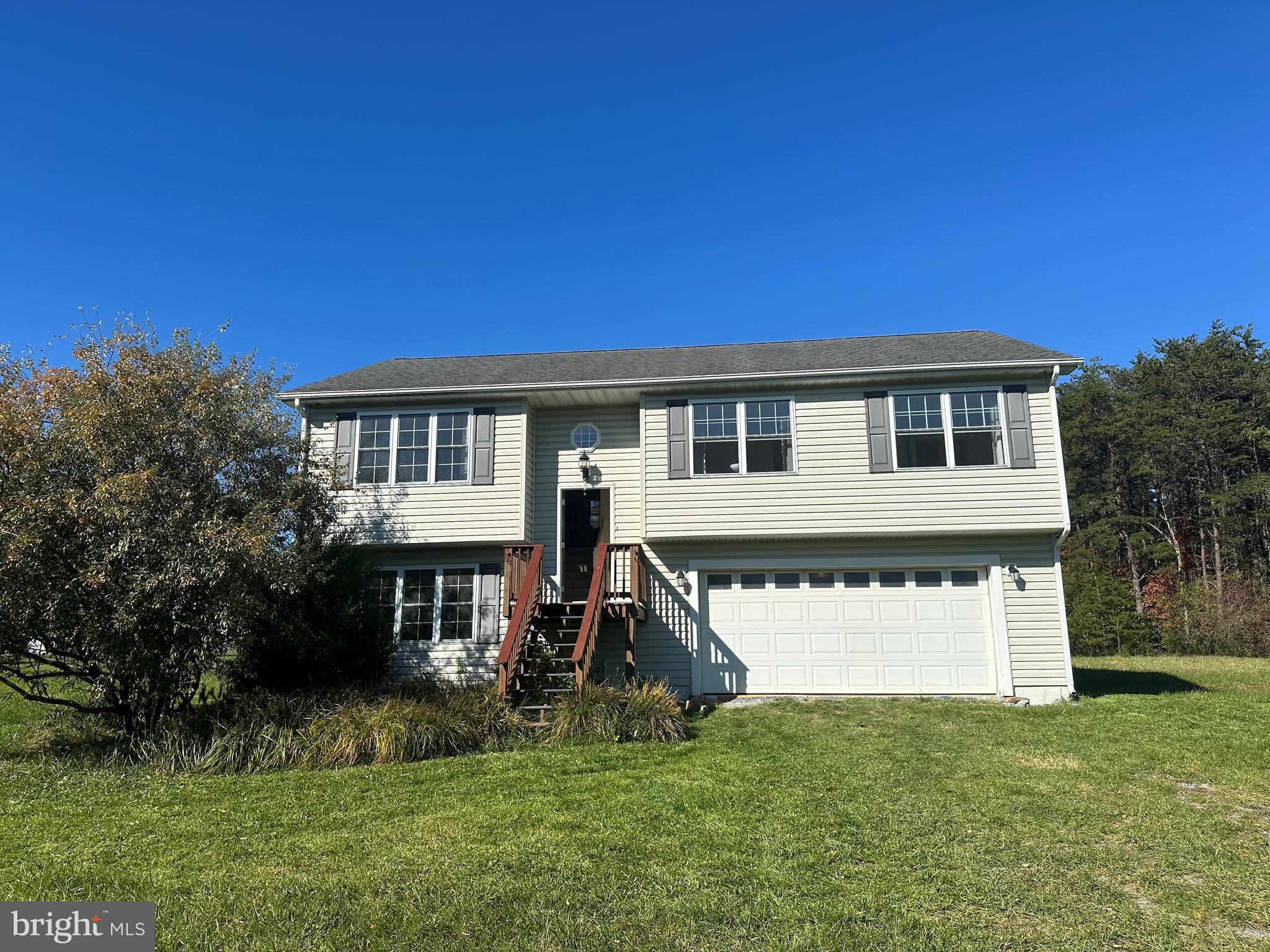 a view of a house with a yard and a tree