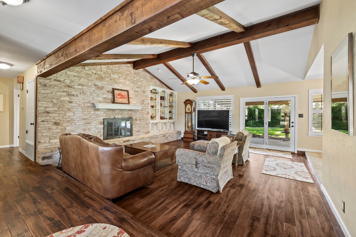 Spacious living room is enhanced by a fireplace with a stunning stacked stone wall.