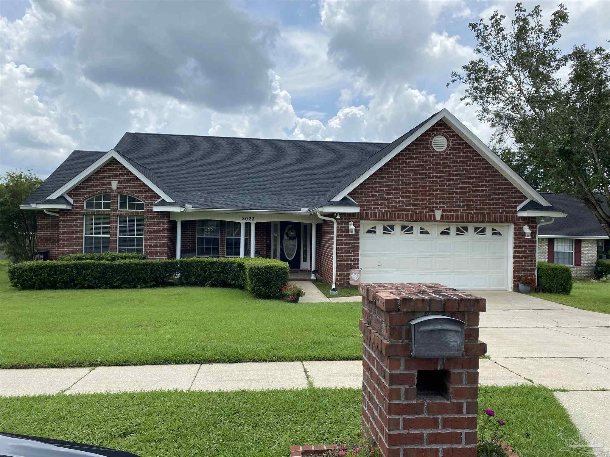 a front view of a house with a garden and yard