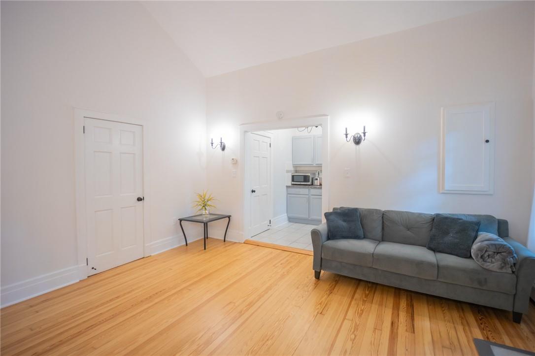 Living room featuring high vaulted ceiling and light wood-type flooring