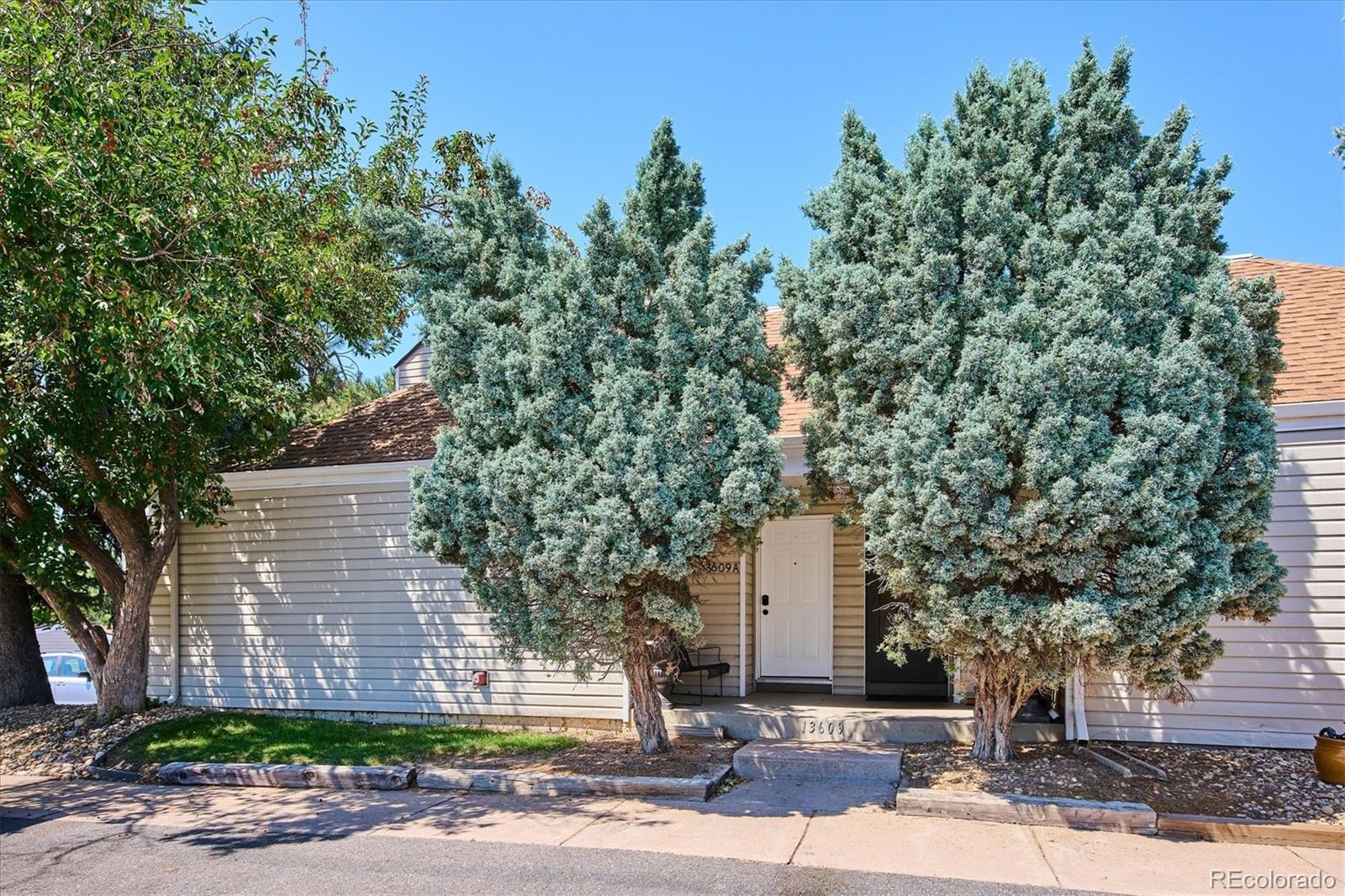 a front view of a house with a yard and tree s