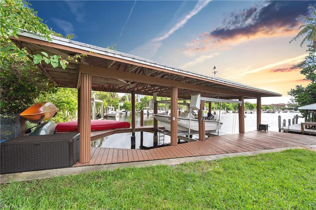 View of dock featuring a lawn and a water view