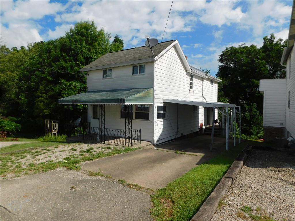 a front view of a house with a yard and trees