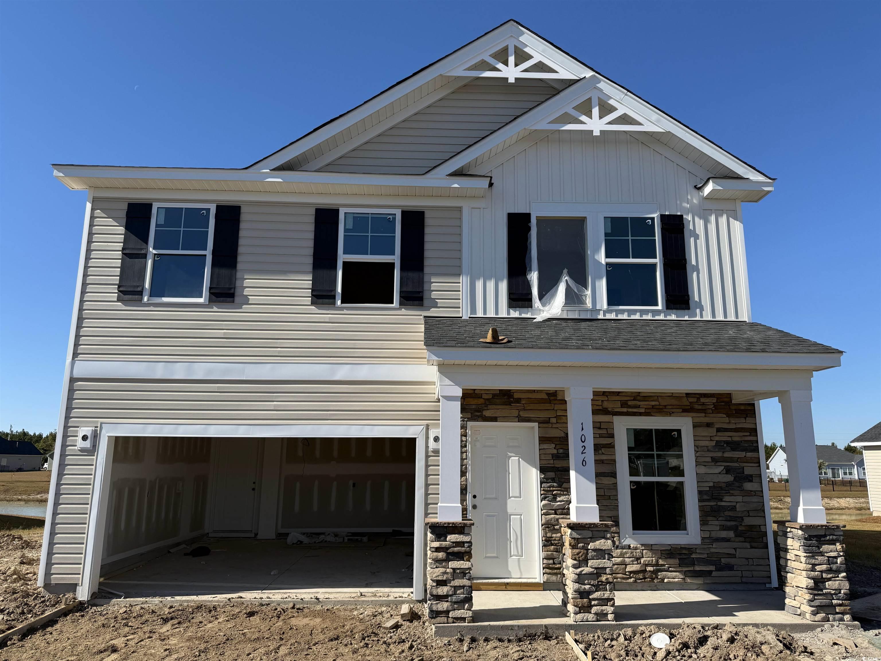 View of front of house with a porch and a garage