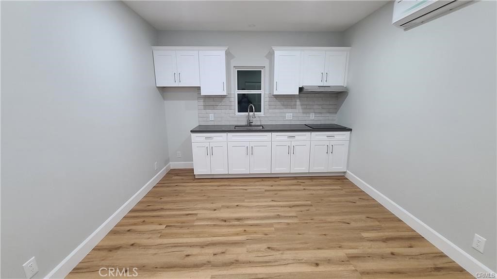 a kitchen with granite countertop a sink stove and cabinets