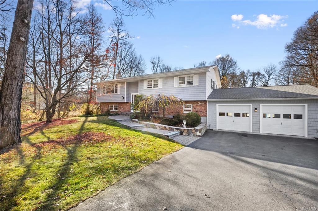 Bi-level home with a front yard and a garage