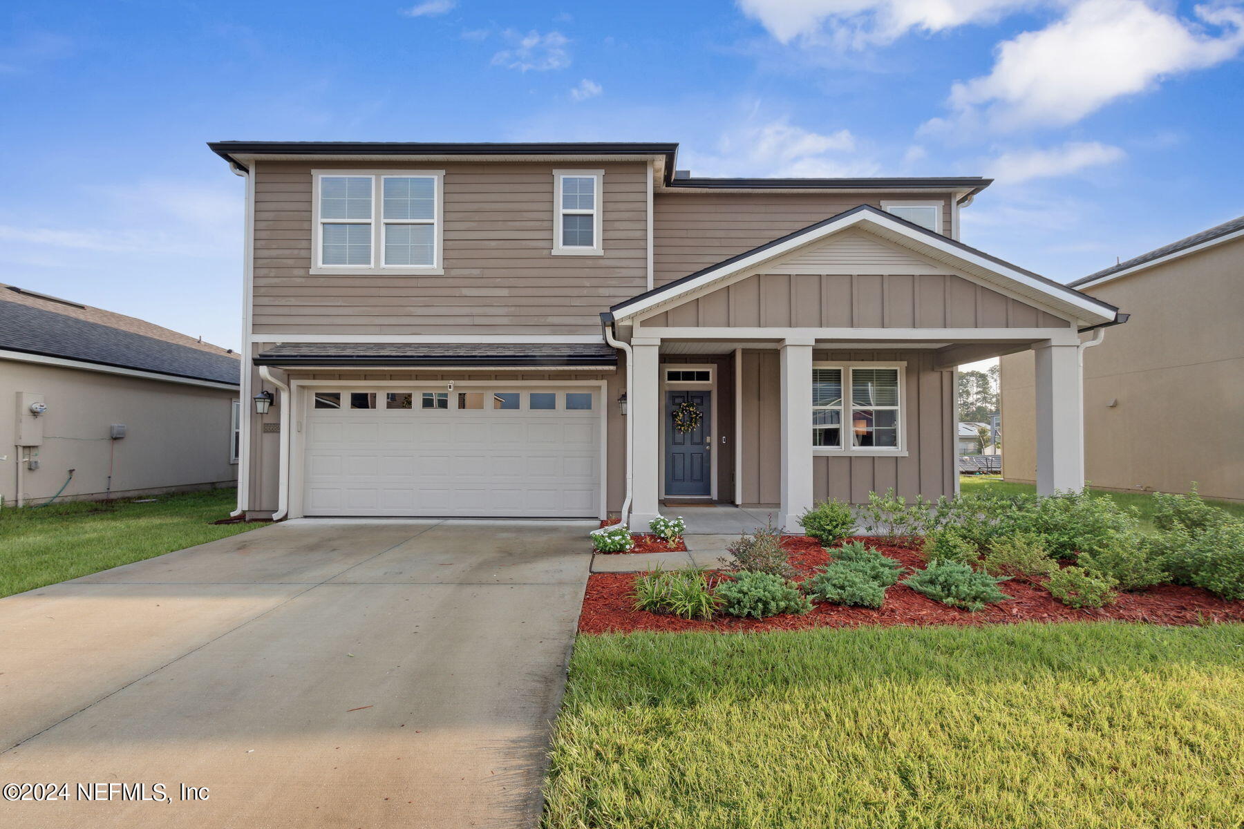 a front view of a house with a garden and garage