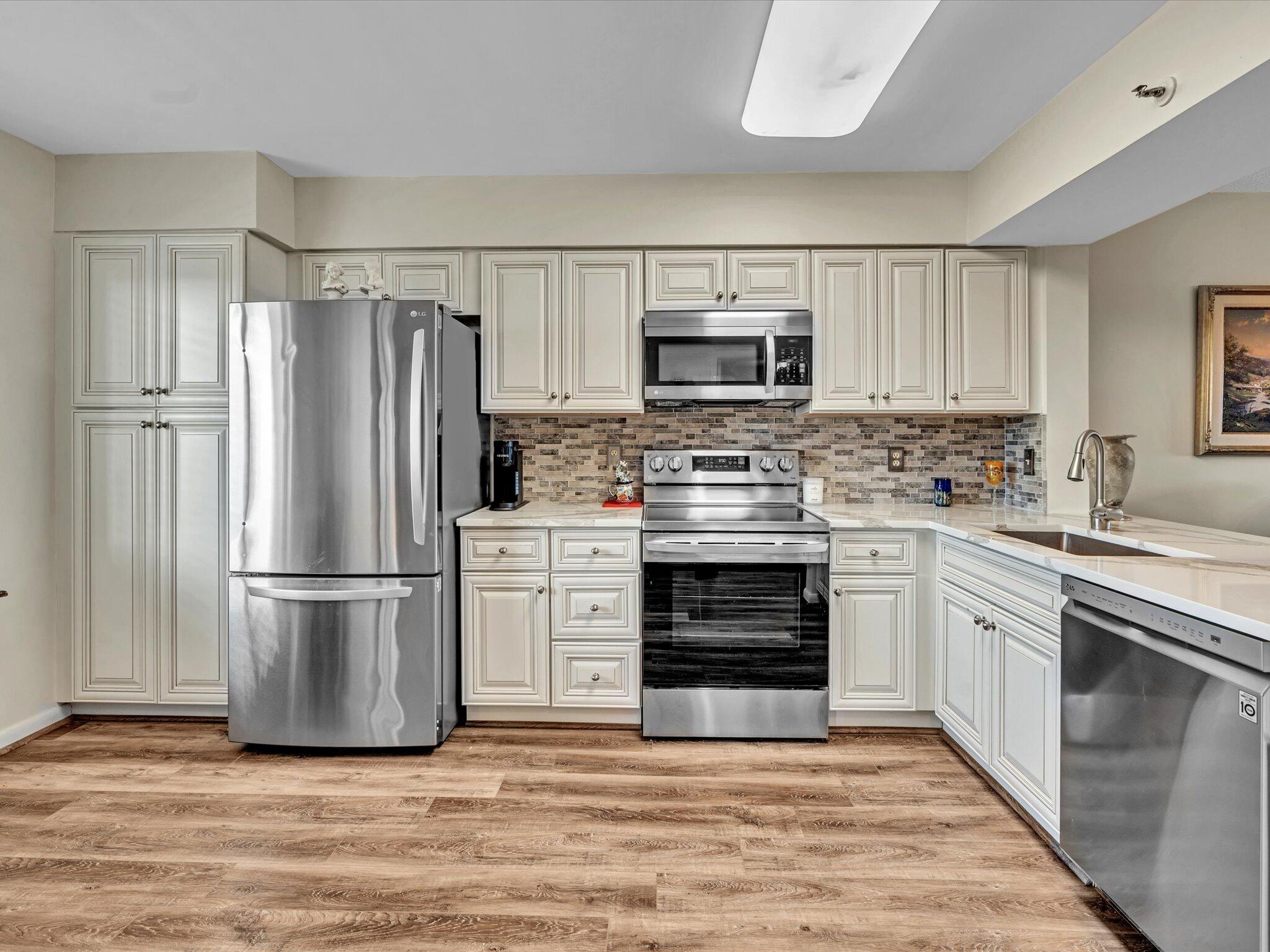 a kitchen with stainless steel appliances a refrigerator sink and microwave