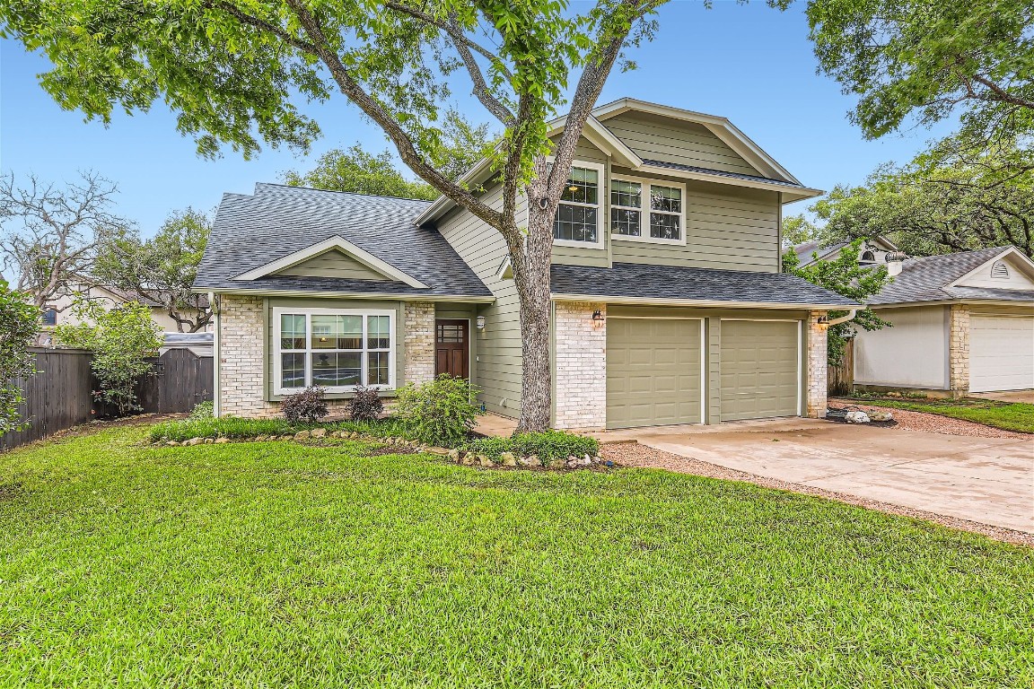 a front view of a house with a garden and yard