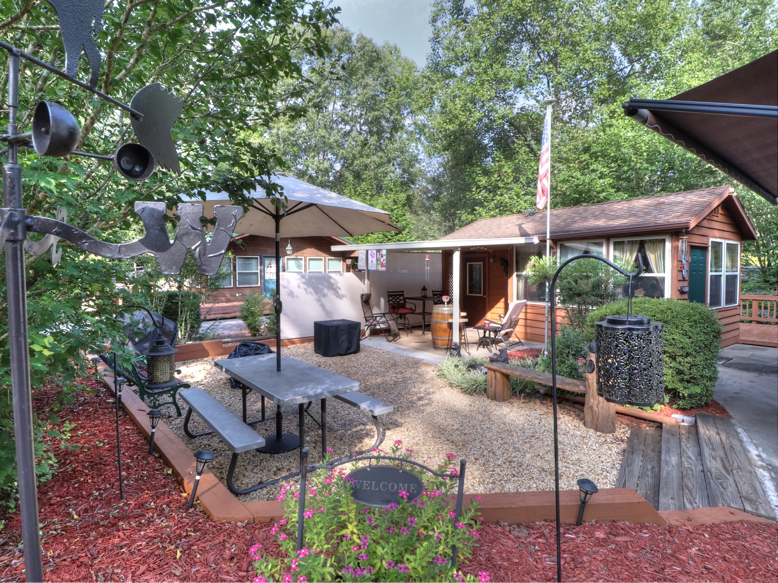 a view of a patio with couches table and chairs under an umbrella