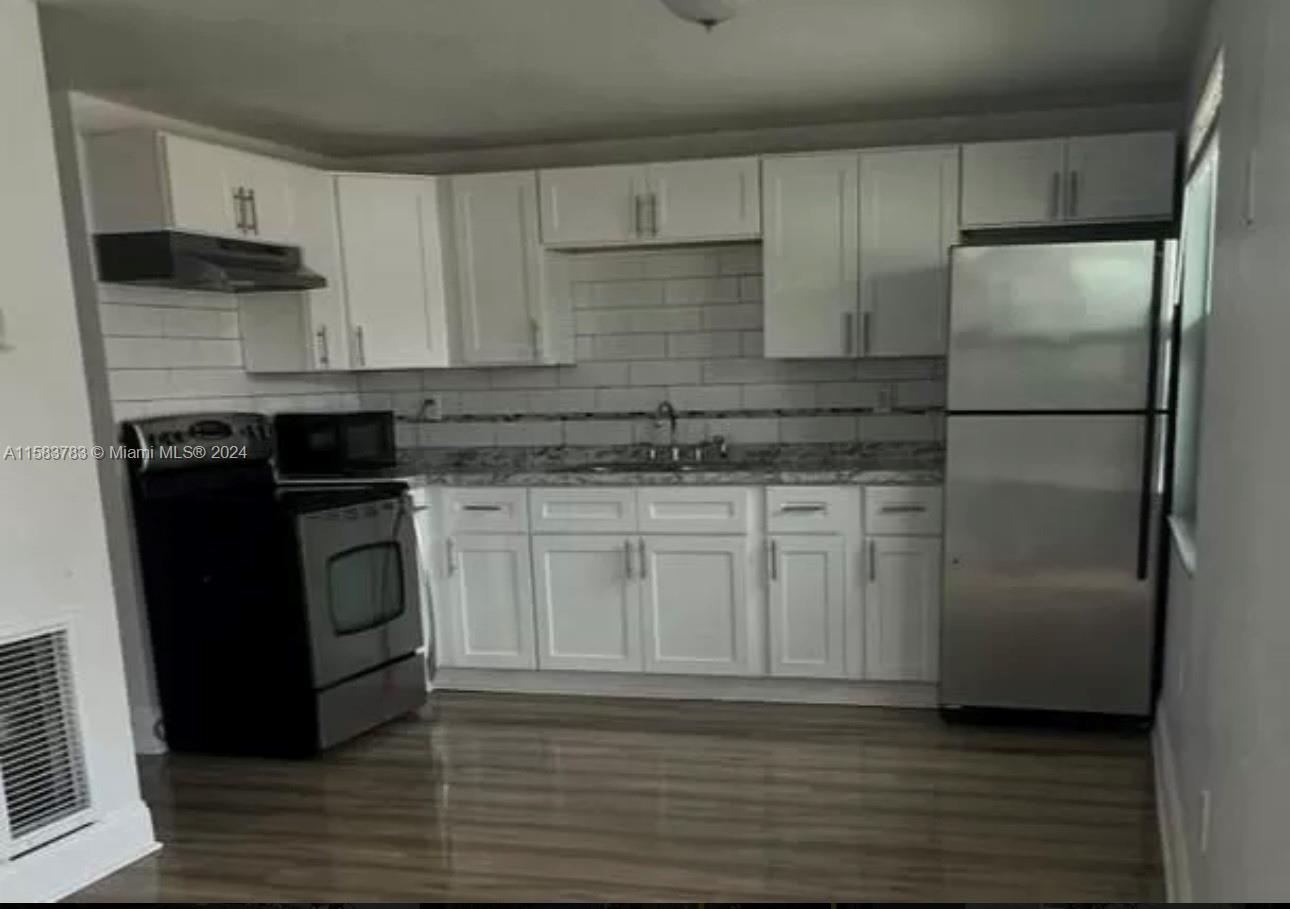 a kitchen with a refrigerator sink and cabinets