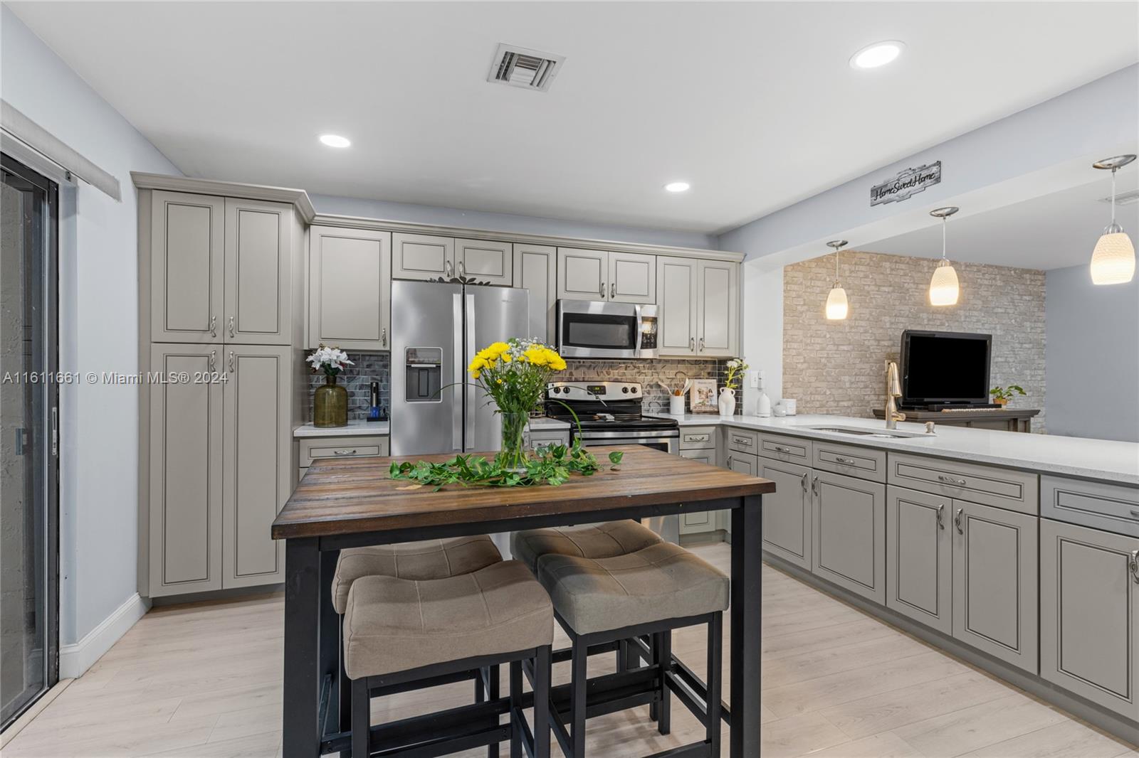 a kitchen with a table chairs refrigerator and microwave