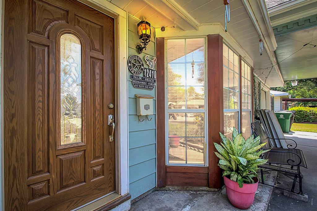 a view of front door with potted plants