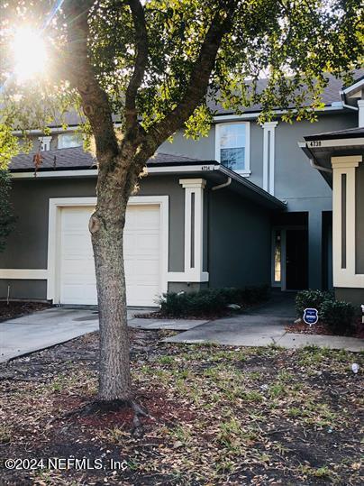 a view of a house with a tree in the yard