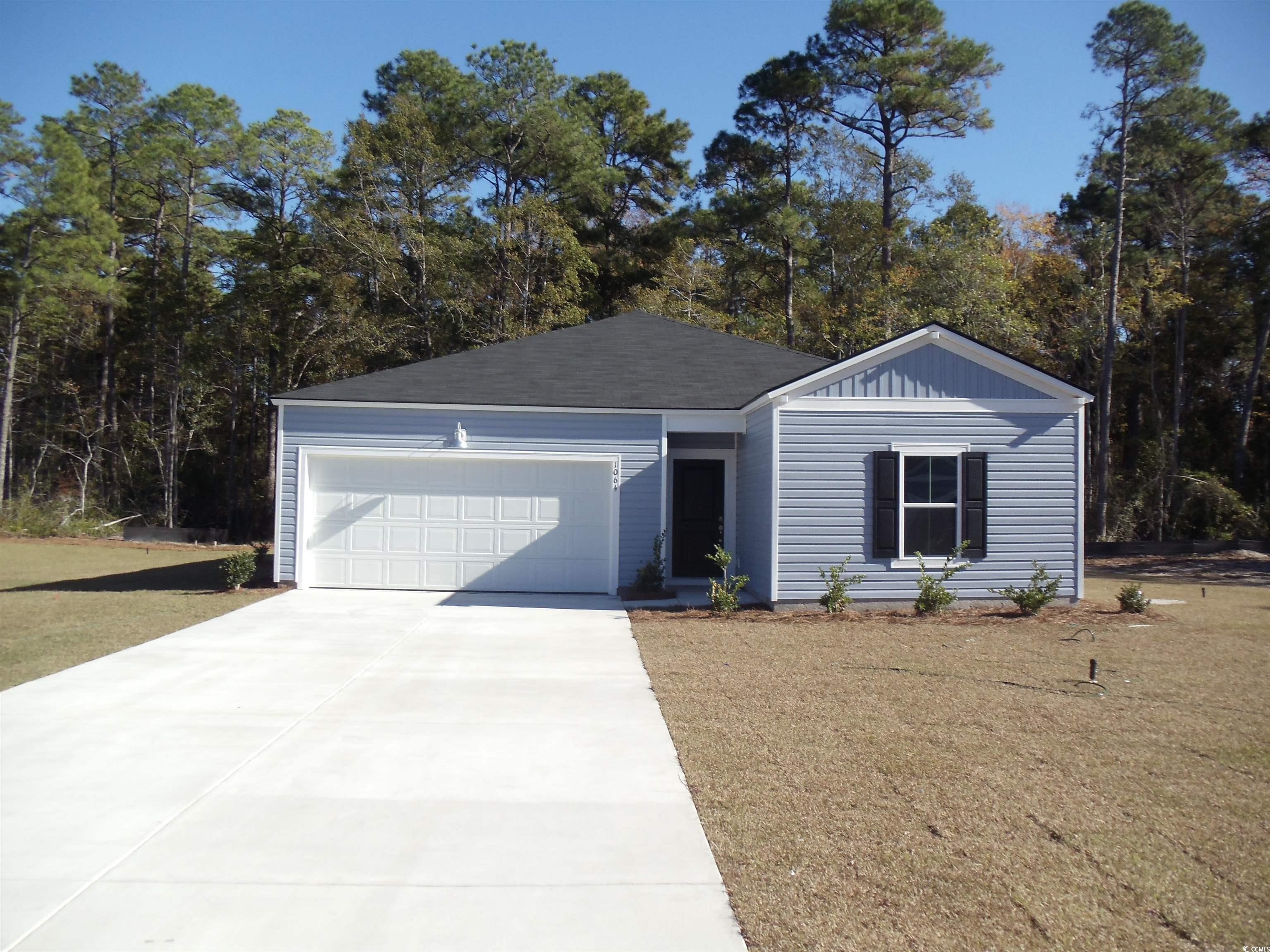 View of front of home with a front lawn and a gara