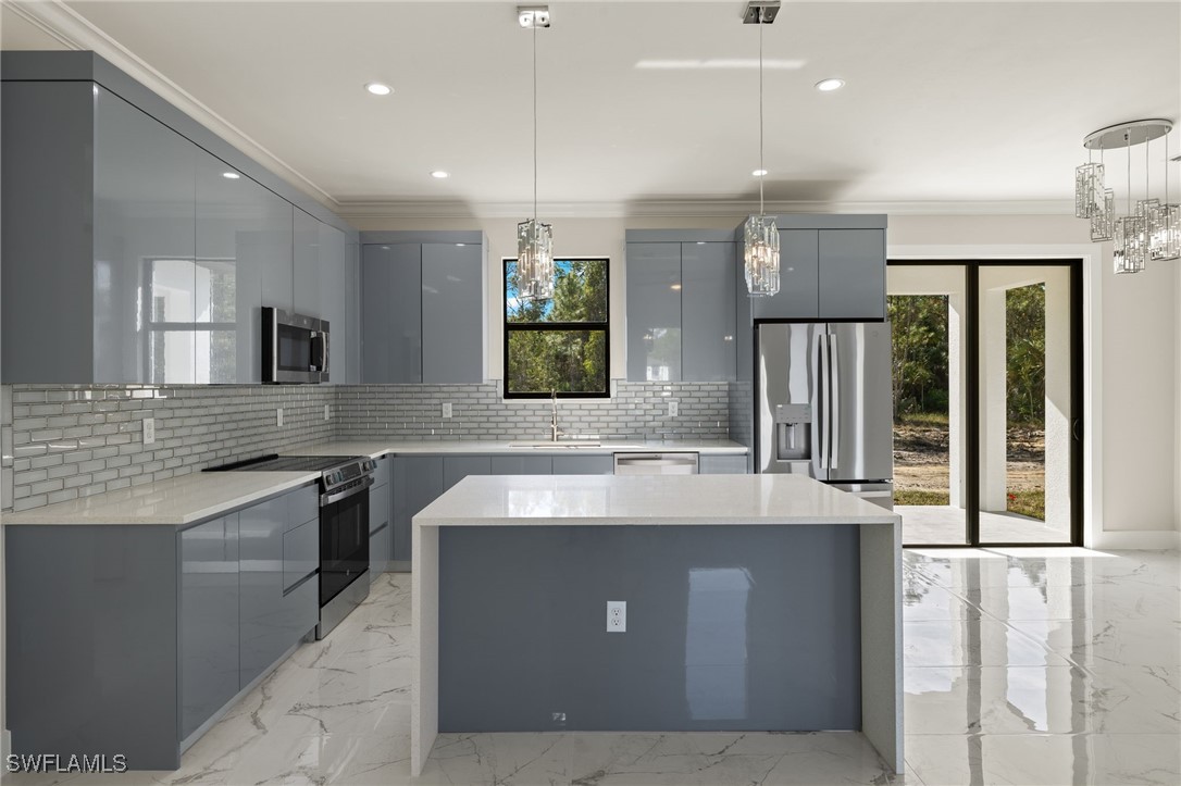 a large kitchen with kitchen island a large counter top space a sink stainless steel appliances and cabinets