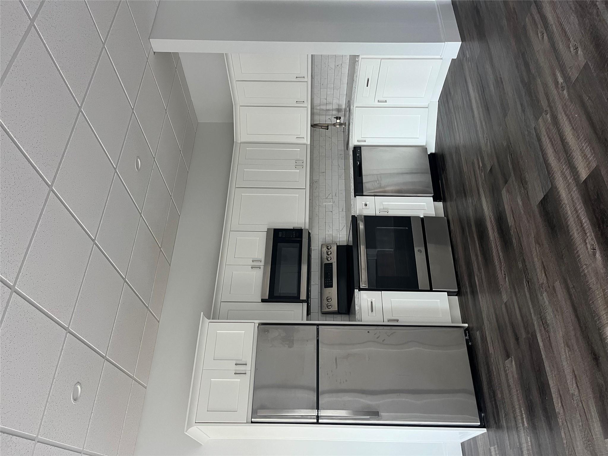 Kitchen with backsplash, white cabinetry, sink, and appliances with stainless steel finishes